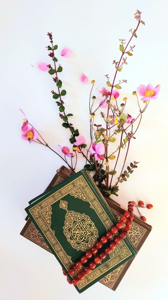 Holy Quran with prayer beads and flowers